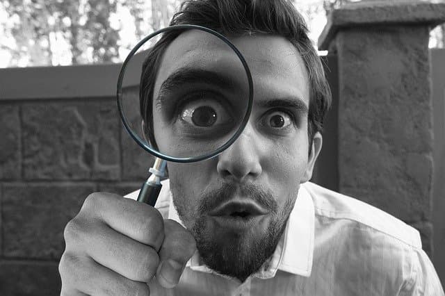 Man looking through magnifying glas for evidence